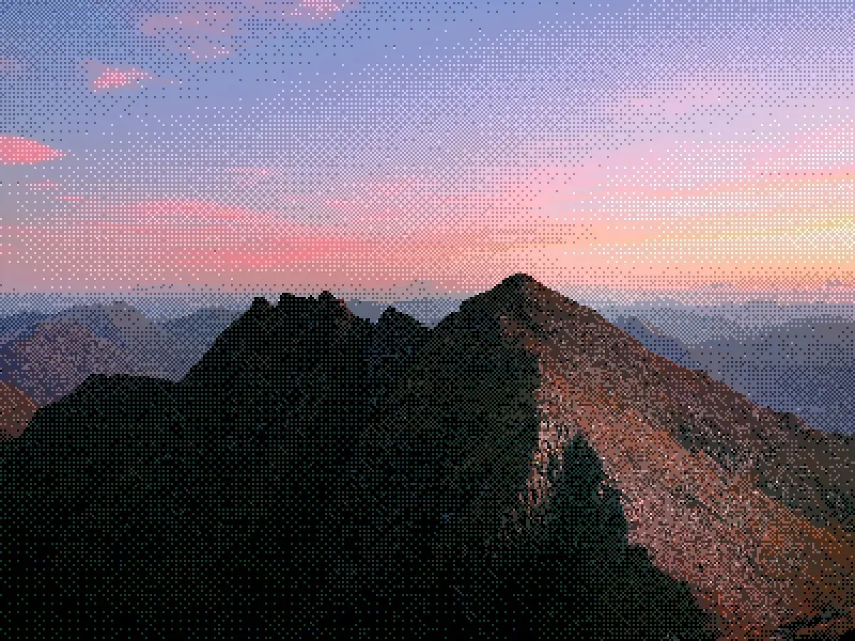 Mountain ridge silhouette against a pink and purple sunset sky