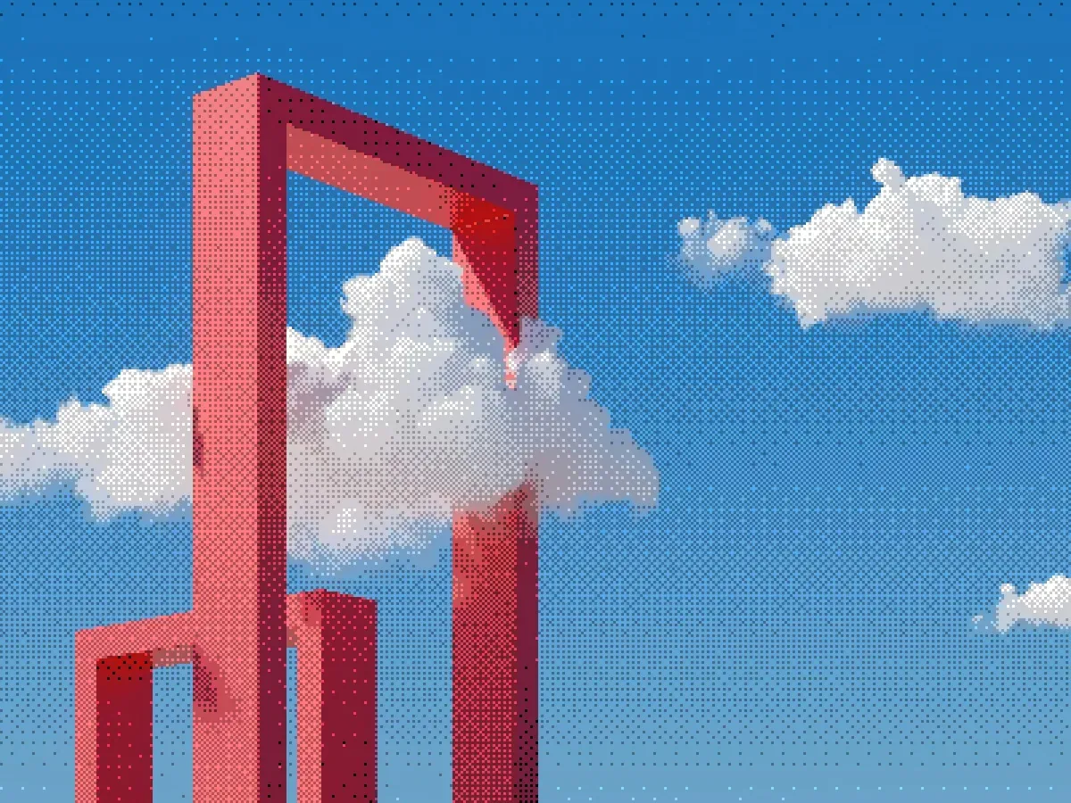Red geometric sculpture framing white clouds against a blue sky